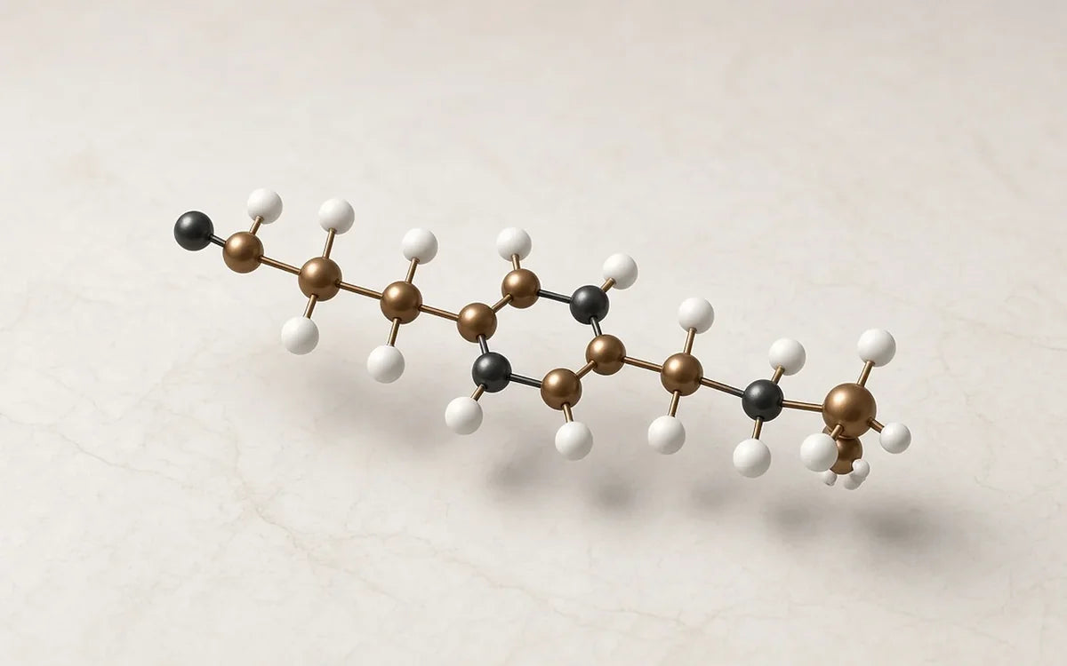 Molecular model of a peptide chain resting on a pale stone surface